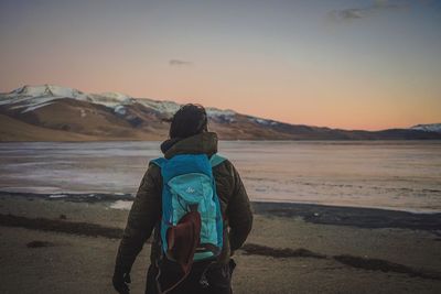 Rear view of man looking at sea against sky