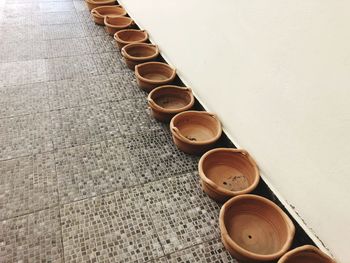 High angle view of bowls arranged on floor by wall