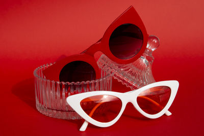 Close-up of sunglasses on table against red background