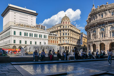 Tourists in piazza de ferrari square in the city center of genoa, liguria, italy