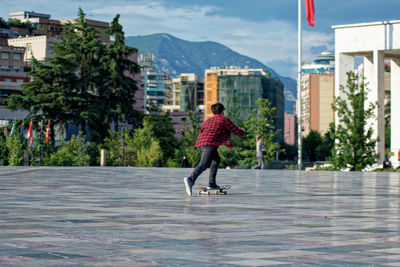 Rear view of woman walking against buildings in city