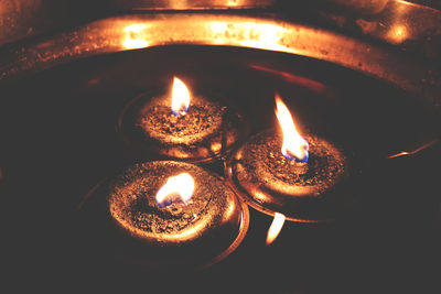 Close-up of lit candle in the dark