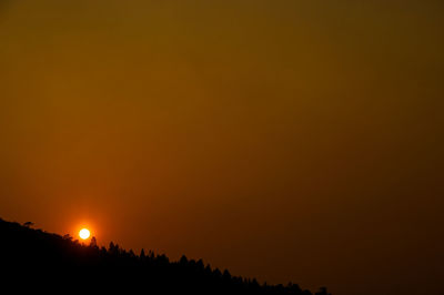 Scenic view of silhouette landscape against orange sky