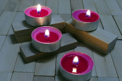 High angle view of lit tea light candles on table