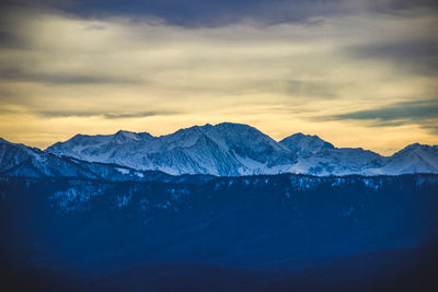 Scenic view of snowcapped mountains against sky during sunset