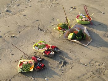 High angle view of buddhist offering on sand at beach