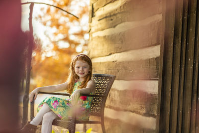 Portrait of young woman sitting on chair