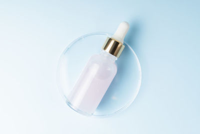 Skin care essence oil dropper glass bottle on blue background. hydrating serum, vitamin for face 