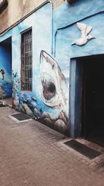 Cat lying on wall of building