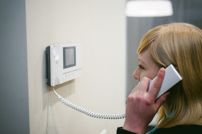 Close-up of young woman talking on phone at home