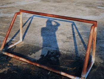 High angle view of shadow of man standing on ladder