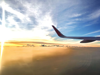 Airplane flying against sky during sunset