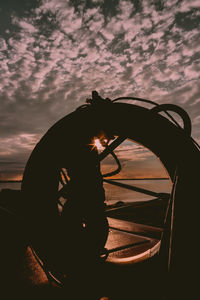 Silhouette man by car against sky during sunset