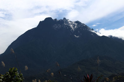 Scenic view of mountain range against cloudy sky