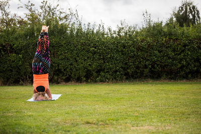 Rear view of woman standing on field