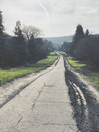 Road amidst trees against sky