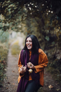 Portrait of smiling young woman in forest