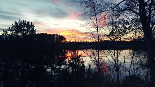 Reflection of trees in lake during sunset