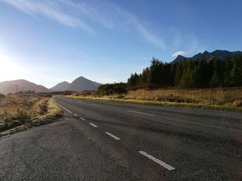 Road by mountains against sky