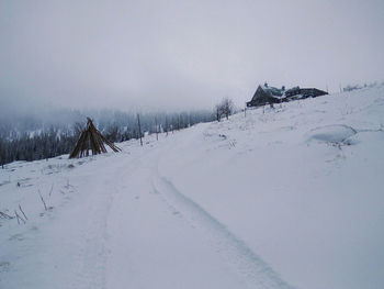 Snow covered landscape against sky