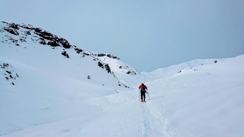 Rear view of woman skiing on snowcapped mountains during winter