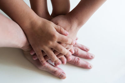 Midsection of woman holding hands over white background