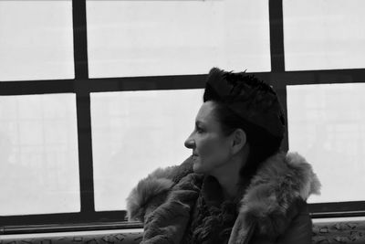 Close-up of young woman looking through window