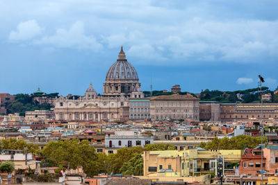 View of buildings in city against cloudy sky