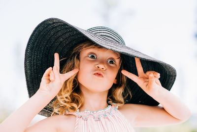 Portrait of a young girl pulling funny faces at the camera outside