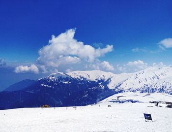 Scenic view of snowcapped mountains against blue sky