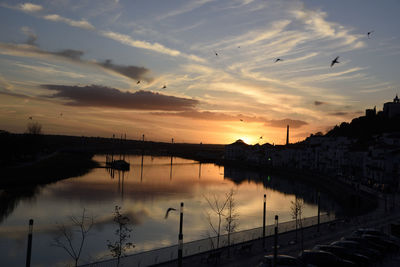 Scenic view of river against sky at sunset