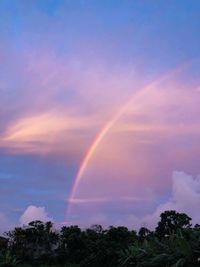 Low angle view of rainbow against sky at sunset