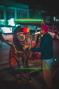 People standing on illuminated street at night