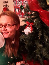 Portrait of a smiling young woman with christmas tree