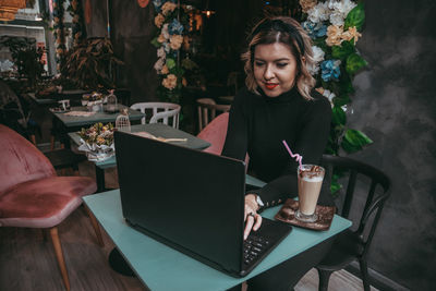 Woman sitting on table in restaurant