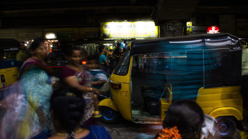 People on illuminated street at night