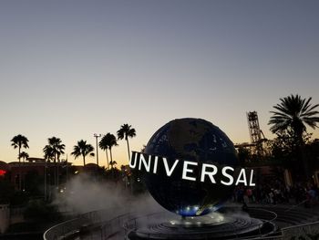 Information sign by swimming pool against clear sky