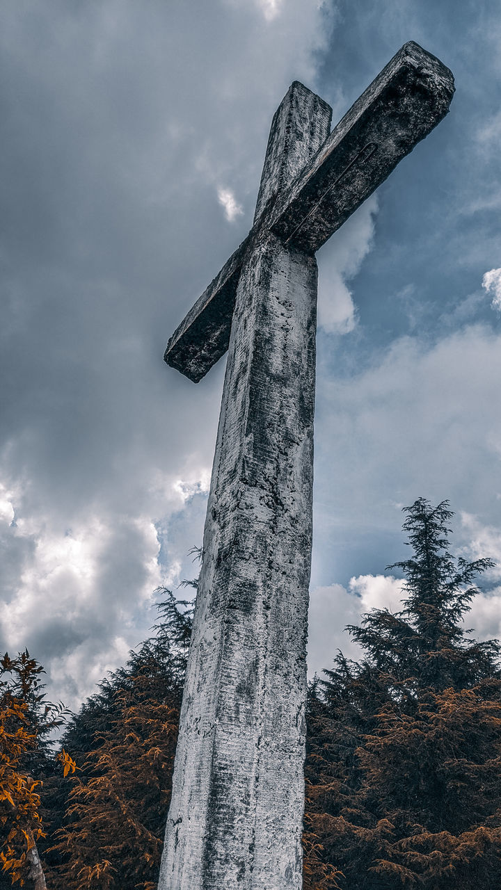 LOW ANGLE VIEW OF CROSS AGAINST TREES