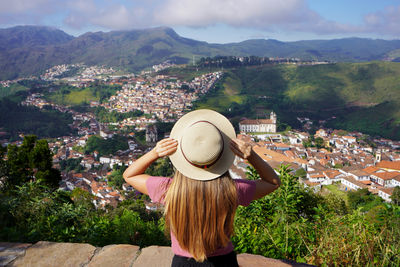 Rear view of woman looking at townscape against mountain