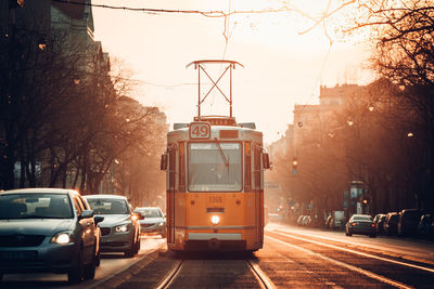 Cars on city street against sky