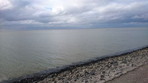 View of calm sea against cloudy sky