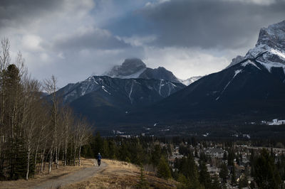 Rear view of person on snowcapped mountains against sky