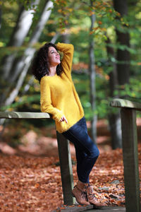 Full length of young woman in autumn tree