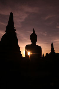 Silhouette statue of building at sunset