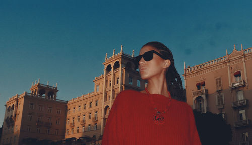 Portrait of woman standing against buildings