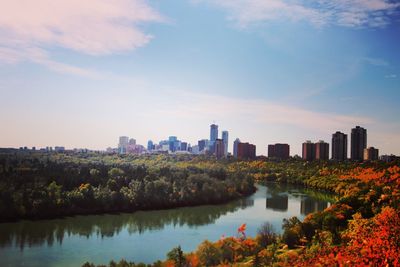 Scenic view of lake by buildings against sky