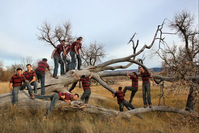 Multiple image of man on tree at field