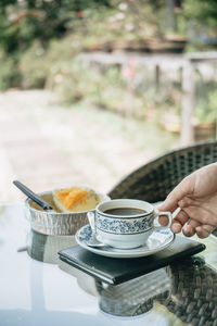 Midsection of person holding coffee cup