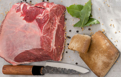 Directly above shot of beef with herbs and knife in plate