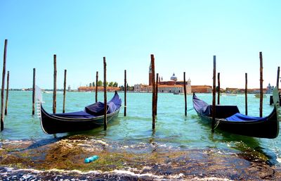 Boats moored on wooden post in water